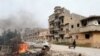 A man pulls a wheelbarrow past destroyed buildings after clashes between military forces loyal to Libya's eastern government and Islamist fighters, in Benghazi, Libya, Feb. 28, 2016. 