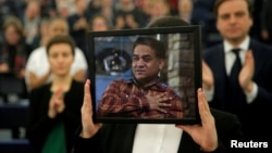 (FILE) Jewher Ilham, daughter of Ilham Tohti, Uyghur economist and human rights activist, holds a portrait of her father.