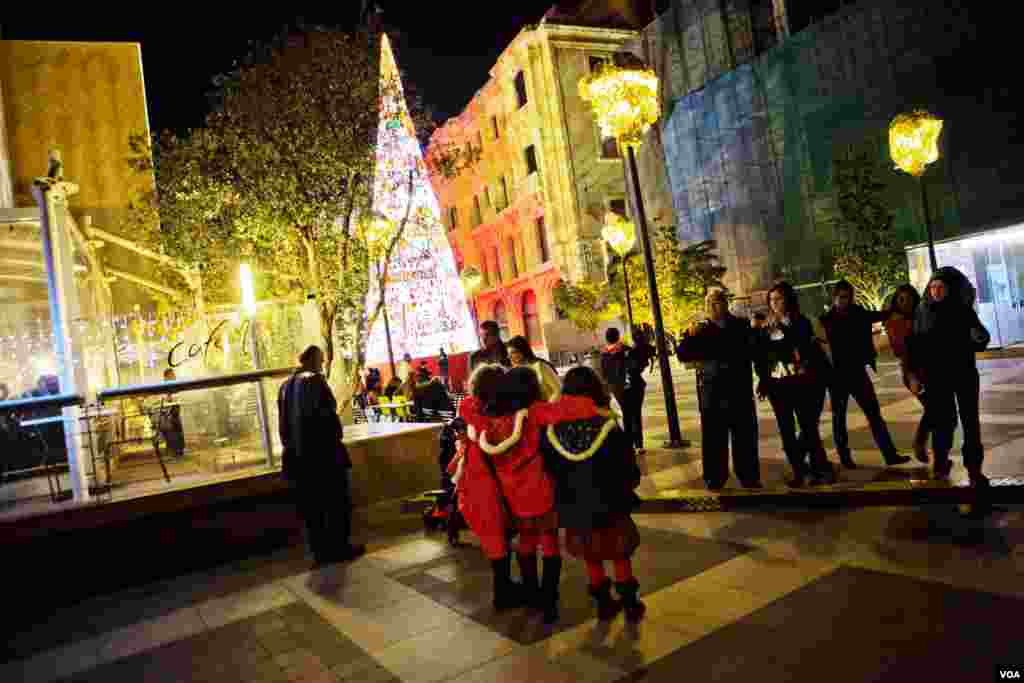 Beirut families take photos in front of Christmas trees and decorations in the new Souk shopping district, Lebanon, December 2012. (VOA/V. Undritz)