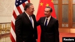 U.S. Secretary of State Mike Pompeo chats with Chinese Foreign Minister Wang Yi before their meeting at the Great Hall of the People in Beijing, China, June 14, 2018. 