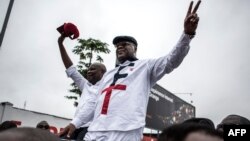 Congolese opposition figures, leader of the Union for Democracy and Social Progress, Felix Tshisekedi, right, and his running mate leader of the Union for the Congolese Nation Vital Kamerhe wave from a car to their supporters, Nov. 27, 2018, in Kinshasa.