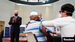 Presidenti Joe Biden duke duartrokitur gjatë vaksinimeve në Aleksandria, Virxhinia (6 prill 2021, REUTERS/Kevin Lamarque)