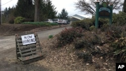 FILE - This March 2, 2017, photo shows a sign saying "Now Hiring" in front of Brooks Tree Farm near Salem, Ore. 
