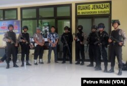 Sejumlah polisi berjaga di depan ruang jenazah RS Bhayangkara Polda Jawa Timur (Foto: VOA/Petrus Riski).