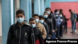 Palestinian students wait to receive a dose of the Pfizer-BioNTech vaccine against COVID-19 at a school of the UN Relief and Works Agency (UNRWA) in Gaza's al-Shati refugee camp, Jan. 24, 2022.