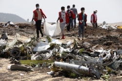 FILE - Ethiopian Red Cross workers carry a body bag with the remains of Ethiopian Airlines Flight ET 302 plane crash victims at the scene of a plane crash, near the town of Bishoftu, southeast of Addis Ababa, Ethiopia March 12, 2019. (REUTERS/Baz Ratner)