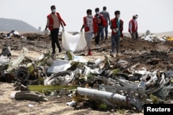 FILE - Ethiopian Red Cross workers carry a body bag with the remains of Ethiopian Airlines Flight ET 302 plane crash victims at the scene of a plane crash, near the town of Bishoftu, southeast of Addis Ababa, Ethiopia March 12, 2019. (REUTERS/Baz Ratner)