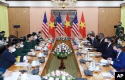 U.S Defense Secretary Lloyd Austin, third from right, and Vietnamese Defense Minister Phan Van Giang, third from left, hold a meeting in Hanoi, Vietnam, Thursday, July 29, 2021. (Nguyen Trong Duc/VNA via AP)