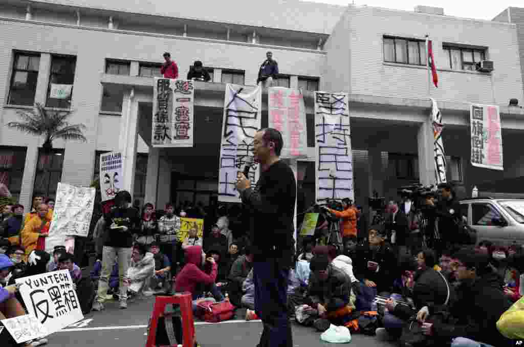 A professor speaks to students during a protest outside the Taiwan legislature in Taipei, March 20, 2014. 