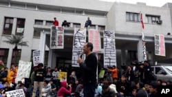 FILE - A professor speaks to students during a protest outside Taiwan's legislature in Taipei, March 20, 2014. 