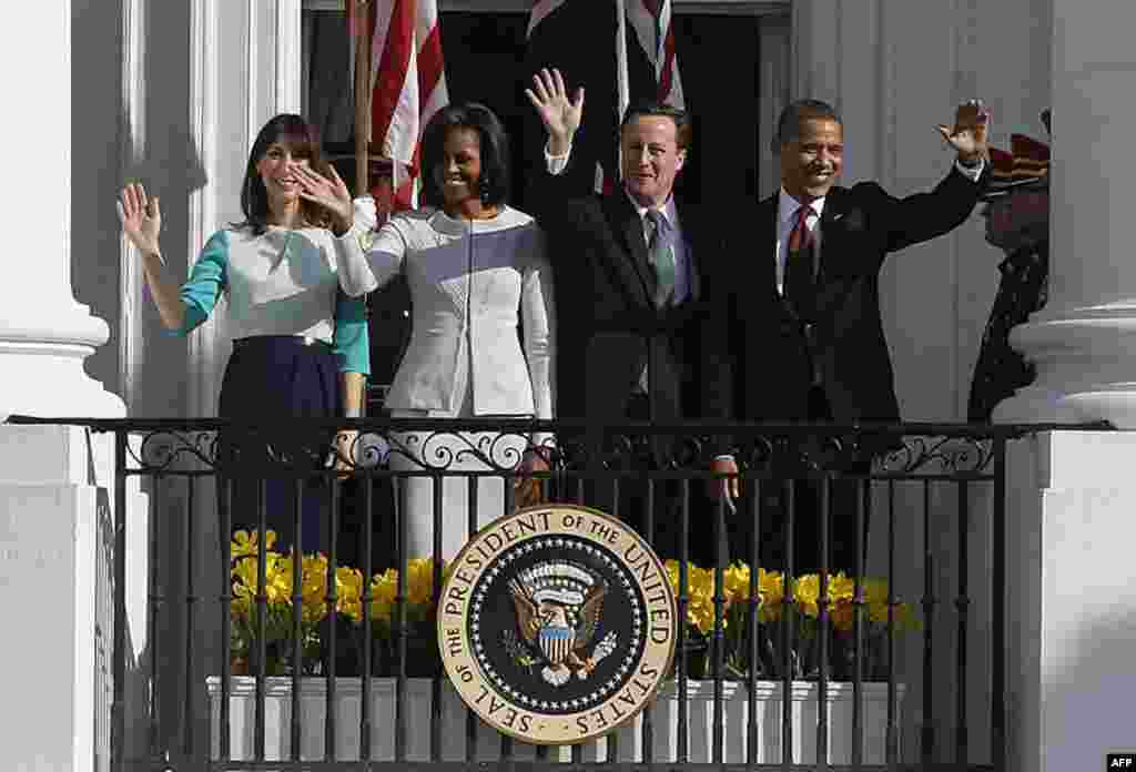 The Obamas wave with the Camerons from the South Portico balcony of the White House during an official arrival ceremony for the British leader and his wife. (AP)