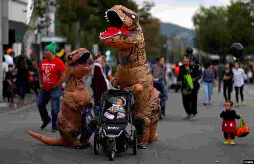 People wearing costumes walk during Halloween in Sierra Madre, California, Oct. 31, 2017.