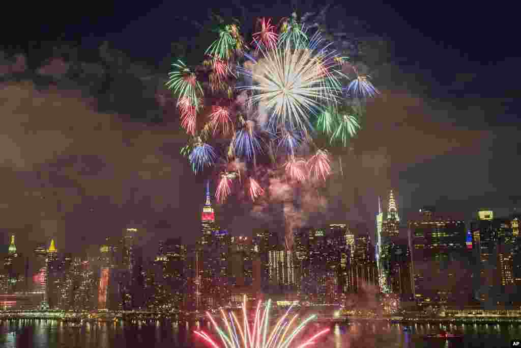 Dengan pemandangan pencakar langit New York City di latar belakang, kembang api meledak dalam atraksi Hari Kemerdekaan di atas East River, 4 Juli 2017.