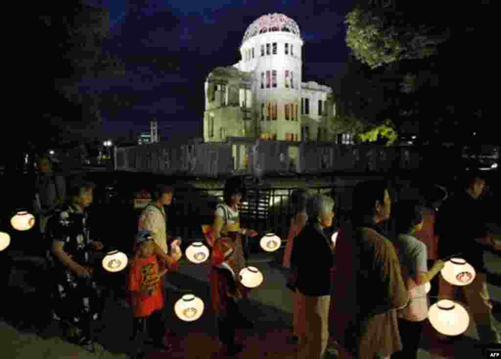 Buddhist followers parade with lanterns in their hands in prayer for peace around the illuminated Atomic Bomb Dome in Hiroshima, western Japan on the eve of the 66th anniversary of the world's first atomic bombing on the city, Friday, Aug. 5, 2011. (AP Ph