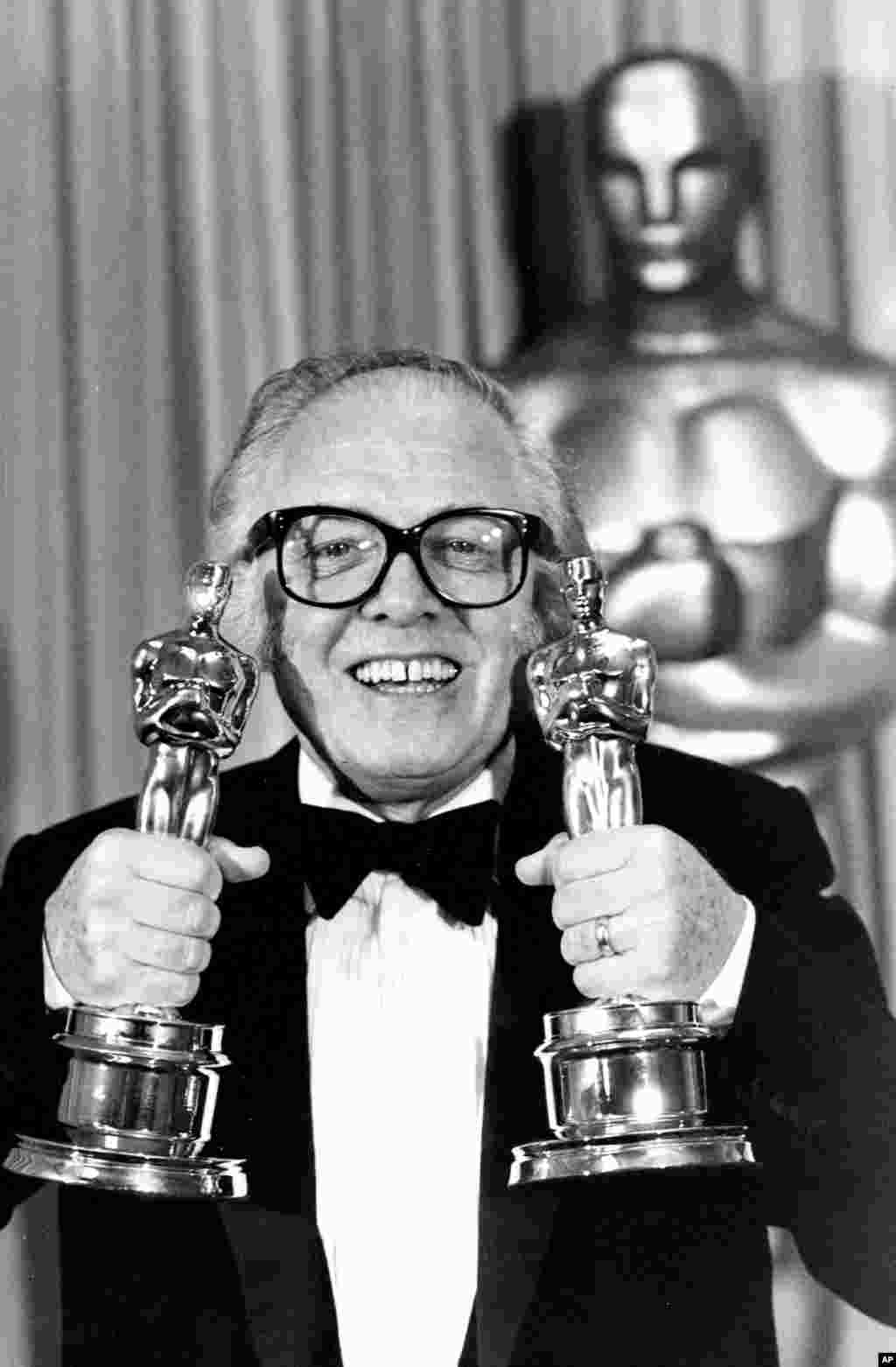In this Monday, April 11, 1983 file photo, British actor and director Richard Attenborough holds his two Oscars for his movie &quot;Gandhi&quot; at the 55th annual Academy Awards in Los Angeles.