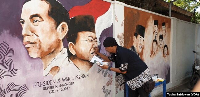 Seniman Solo aksi mural menggambar wajah Presiden Jokowi dan Wapres Ma'ruf Amin di dinding kampung Gremet Manahan Solo