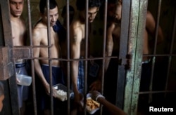 Inmates line up for food provided by the prison in Pavilion No.2 in La Joya prison on the outskirts of Panama City, Panama, Jan. 27, 2016.