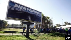 A Goodyear billboard emblazoned with the Spanish word for welcome, is posted near a plant entrance company where workers arrived to find the plant is no longer in operation, in Los Guayabos, Venezuela, Dec. 10, 2018. 