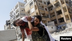 Free Syrian Army fighter carries body of fellow fighter during clashes in Aleppo, August 16, 2012. 