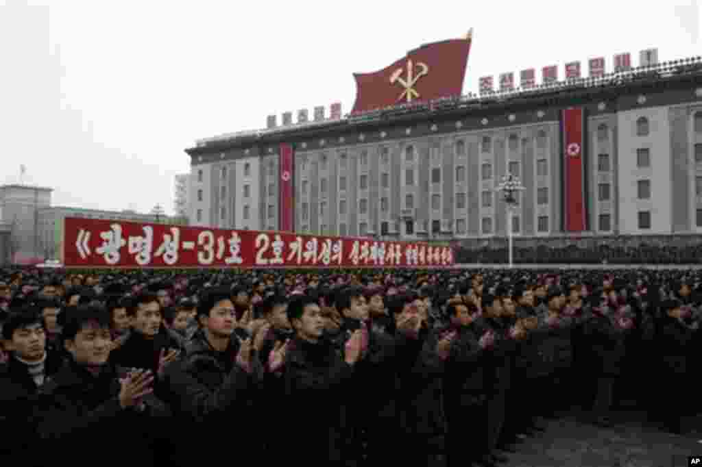 North Koreans applaud near a slogan which reads &ldquo;(we) fervently celebrate the successful launch of the second version of the Kwangmyongsong-3 satellite 2nd version&quot; during a mass rally organized to celebrate the success of a rocket launch that sent a satellite into space at Kim Il Sung Square in Pyongyang, North Korea, Friday, Dec. 14, 2012.&nbsp;