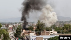 Smoke rises from the site of a blast and gunbattle between Afghan security forces and a handful of militants in Jalalabad city, Afghanistan, May 13, 2018. 