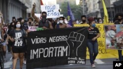 FILE - In this June 11, 2020 file photo, people holding a banner that reads "Black Lives Matter" march during a protest against racism and police violence in Niteroi, Rio de Janeiro, Brazil. (AP Photo/Silvia Izquierdo)