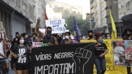 FILE - In this June 11, 2020 file photo, people holding a banner that reads 