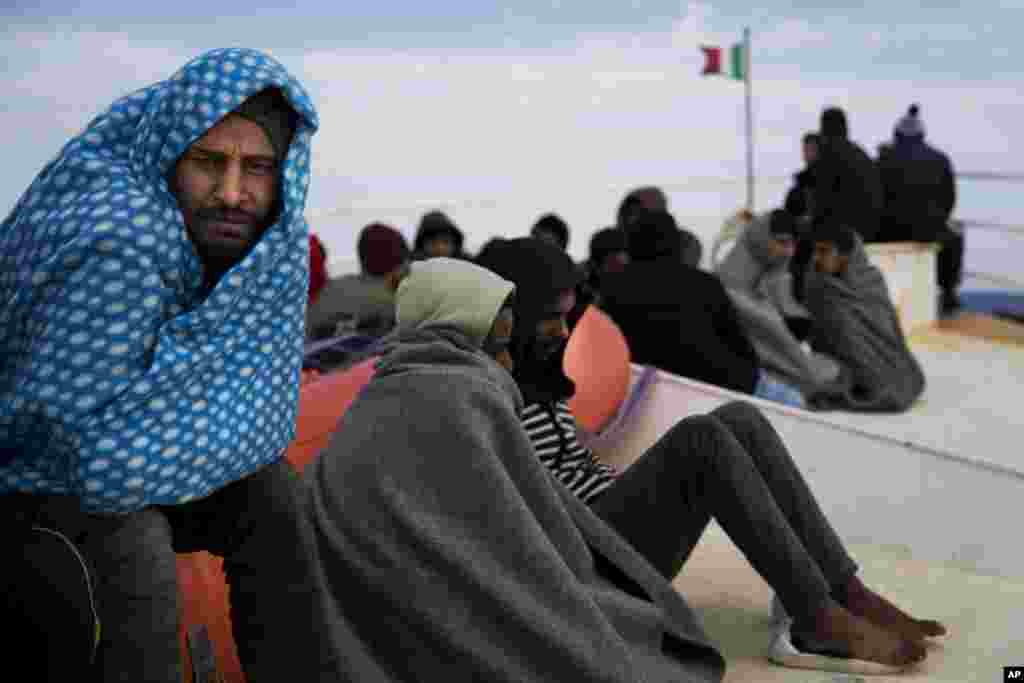 Migrants sit atop the prow of the Golfo Azurro vessel a day after being rescued by members of Proactiva Open Arms NGO.