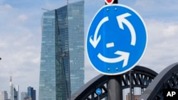 FILE - A traffic sign stands next to the headquarters of the European Central Bank in Frankfurt, Germany, June 16, 2015.