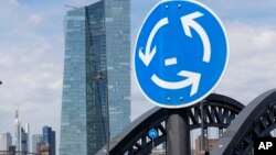 A traffic sign stands next to the headquarters of the European Central Bank in Frankfurt, Germany, June 16, 2015.
