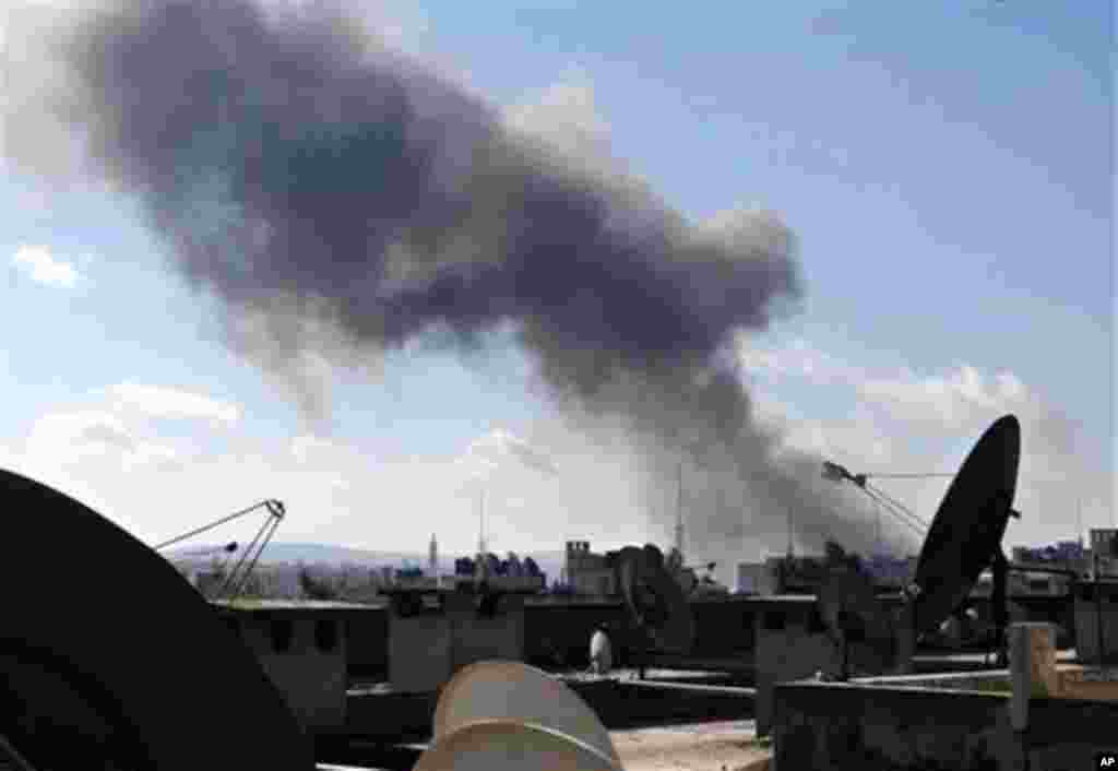 This citizen journalism image provided by Aleppo Media Center AMC which has been authenticated based on its contents and other AP reporting, shows smoke rising from heavy shelling in Aleppo, Syria, Tuesday Feb. 12, 2013. Rebels captured a military air bas