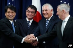 From left, Japanese Defense Minister Itsunori Onodera, Japanese Foreign Minister Taro Kono, Secretary of State Rex Tillerson and Defense Secretary James Mattis shake hands "ASEAN style" at the start of a Security Consultative Committee meeting at the Stat