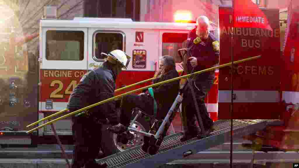 Une femme est transportée dans un fauteuil roulant à un bus d&#39;ambulance où sont conduits les&nbsp; personnes évacuées d&#39;un tunnel de métro de métro enfumée à Washington, lundi 12 janvier, 2015.