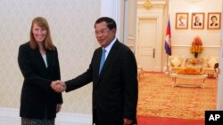 Rhona Smith, left, U.N. special rapporteur on the situation of human rights in Cambodia, poses with Cambodian Prime Minister Hun Sen, for a photo during a meeting at Peace Palace, in Phnom Penh, Cambodia, Monday, Sept. 21, 2015. Rhona on Monday met Hun Sen for her first mission to Cambodia after she replaced her predecessor Surya Prasad Subedi. (AP Photo/Heng Sinith)