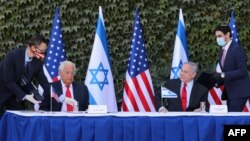 Duta Besar AS untuk Israel David Friedman (kiri) dan Perdana Menteri Israel Benjamin Netanyahu menghadiri penandatanganan perpanjangan perjanjian kerja sama Israel-AS dalam sebuah upacara di Universitas Ariel, di Tepi Barat, 29 Oktober 2020. (Foto: Emil SALMAN / POOL / AFP)