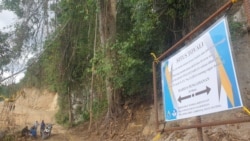 Papan Peringatan larangan aktivitas di area situs Toyali dengan radius pengamanan 20 meter dengan latar alat berat ekskavator beraktivitas di kejauhan. Minggu, 14 Februari 2021. (Foto: Yoanes Litha)