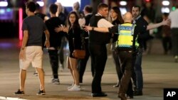 A police officer clears people away from the area near London Bridge after an incident in central London, late Saturday, June 3, 2017.