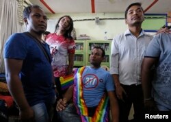 FILE - Gay rights activists watch a news channel covering the Supreme court's decision on gay sex in Mumbai, India, Feb. 2, 2016.
