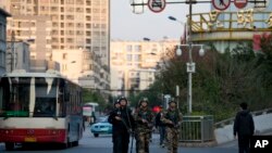 Polisi dan paramiliter bersenjata berpatroli dekat stasiun kereta api Kunming, tempat serangan penusukan yang menewaskan lebih dari 30 orang. (AP/Alexander F. Yuan)