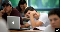 In this Sept. 9, 2013 photo, University of Miami student Gabriel Dias studies the daily lesson plan on his computer during a Spanish class in Coral Gables, Florida.