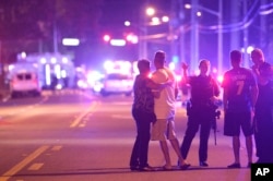 FILE - Orlando police officers direct family members away from a fatal shooting at Pulse Orlando nightclub in Orlando, Florida.