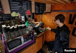 Maksym Havrylendo, CEO OCHIS COFFEE, perusahaan pembuat kacamata, mengambil ampas kopi di sebuah kafe di Kiev, Ukraina, 13 Mei 2019. (Foto: Reuters)