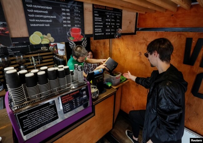 Maksym Havrylendo, CEO OCHIS COFFEE, perusahaan pembuat kacamata, mengambil ampas kopi di sebuah kafe di Kiev, Ukraina, 13 Mei 2019. (Foto: Reuters)