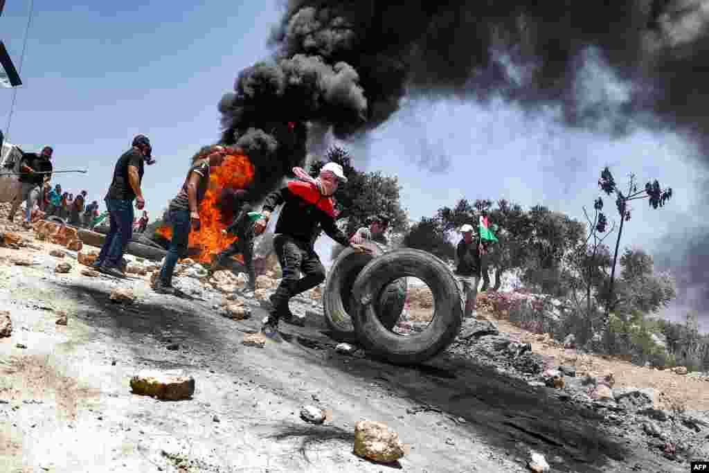 Palestinian protesters set tires aflame during clashes with Israeli security forces following a demonstration in the village of Beita, south of Nablus, in the occupied West Bank.