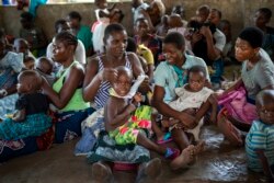 Para ibu menunggu anaknya di Desa Tomali, Malawi, 11 Desember 2019. (Foto: AP)