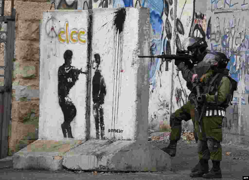 An Israeli security force holds its position during clashes with Palestinian stone throwers following a demonstration in the West Bank town of Bethlehem, demanding that Israeli authorities return the bodies of Palestinians killed during attacks on Israel.