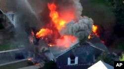 In this image take from video provided by WCVB in Boston, flames consume a home in Lawrence, Mass, a suburb of Boston, Sept. 13, 2018.