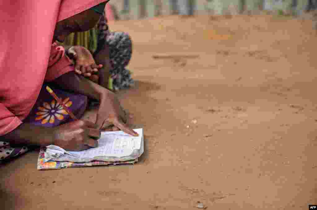 A displaced girl studies the alphabet and numbers at a makeshift school at the Badbado IDP camp in Mogadishu, Somalia, June 25, 2018.