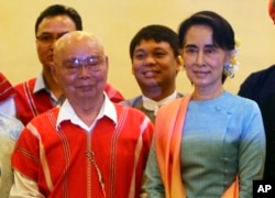 Myanmar's Foreign Minister Aung San Suu Kyi, right, and Mutu Say Po, chairman of Karen National Union (KNU) pose for photos during their meeting at a hotel in Naypyitaw, Myanmar, Aug. 24, 2016.