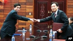 Ketua delegasi Korea Selatan Lee Duk-haeng (kanan) berjabat tangan dengan ketua delegasi Korea Utara Park Yong Il setelah penandatanganan perjanjian terkait reuni keluarga Korea di Tongilgak, wilayah perbatasan Panmunjom, Korea Selatan (Foto: dok).